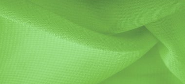 Doku. şablon. Açık yeşil ipek polyester. Kireç yeşili ipek kumaştan. Şeffaf arkaplan ve elbise dikmek için açık kumaştan yapılmış. Tekstil panoraması