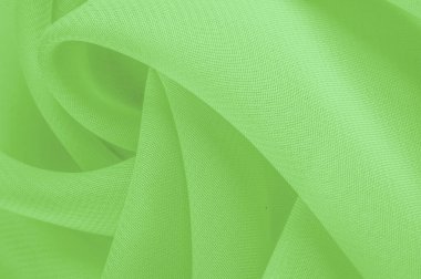 Doku. şablon. Açık yeşil ipek polyester. Kireç yeşili ipek kumaştan. Şeffaf arkaplan ve elbise dikmek için açık kumaştan yapılmış. Tekstil panoraması