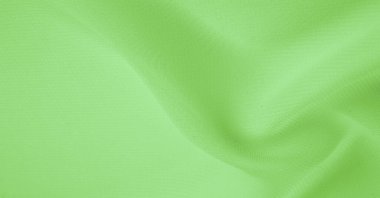 Doku. şablon. Açık yeşil ipek polyester. Kireç yeşili ipek kumaştan. Şeffaf arkaplan ve elbise dikmek için açık kumaştan yapılmış. Tekstil panoraması
