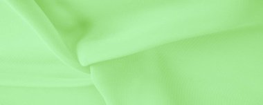 Doku. şablon. Açık yeşil ipek polyester. Kireç yeşili ipek kumaştan. Şeffaf arkaplan ve elbise dikmek için açık kumaştan yapılmış. Tekstil panoraması