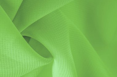 Doku. şablon. Açık yeşil ipek polyester. Kireç yeşili ipek kumaştan. Şeffaf arkaplan ve elbise dikmek için açık kumaştan yapılmış. Tekstil panoraması