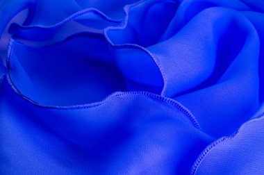 Dalgalı boruları olan mavi ipek bir organza. Kumaşın kenarındaki sınır. Soyut arkaplan. doku deseni. İpek organzanın narin bir açık dokuması vardır. Dalga arkaplanı. Boşluğu kopyala