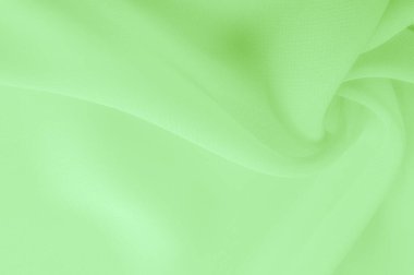 Doku. şablon. Açık yeşil ipek polyester. Kireç yeşili ipek kumaştan. Şeffaf arkaplan ve elbise dikmek için açık kumaştan yapılmış. Tekstil panoraması