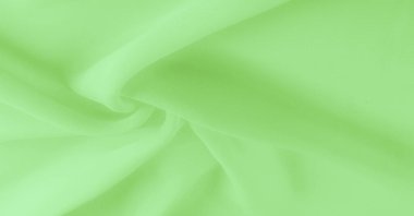 Doku. şablon. Açık yeşil ipek polyester. Kireç yeşili ipek kumaştan. Şeffaf arkaplan ve elbise dikmek için açık kumaştan yapılmış. Tekstil panoraması