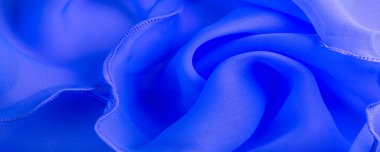 Dalgalı boruları olan mavi ipek bir organza. Kumaşın kenarındaki sınır. Soyut arkaplan. doku deseni. İpek organzanın narin bir açık dokuması vardır. Dalga arkaplanı. Boşluğu kopyala