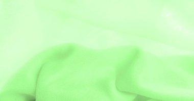 Yeşil kumaş. Lüks kumaşın soyut arka planı ya da dalgaların sıvı ipek dokusu ya da dalgalı kıvrımlar. arka plan ya da zarif duvar kağıdı tasarımı. Pamuk dokusu, doğal kumaş ve boya, parlak yeşil renk.
