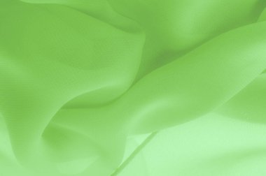 Doku. şablon. Açık yeşil ipek polyester. Kireç yeşili ipek kumaştan. Şeffaf arkaplan ve elbise dikmek için açık kumaştan yapılmış. Tekstil panoraması