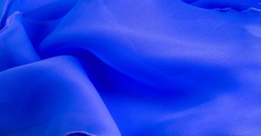 Dalgalı boruları olan mavi ipek bir organza. Kumaşın kenarındaki sınır. Soyut arkaplan. doku deseni. İpek organzanın narin bir açık dokuması vardır. Dalga arkaplanı. Boşluğu kopyala