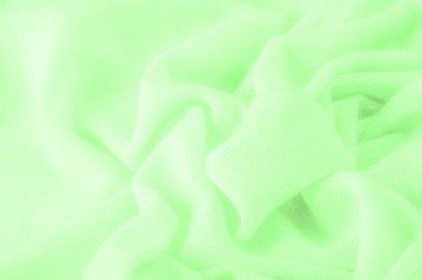 Yeşil kumaş. Lüks kumaşın soyut arka planı ya da dalgaların sıvı ipek dokusu ya da dalgalı kıvrımlar. arka plan ya da zarif duvar kağıdı tasarımı. Pamuk dokusu, doğal kumaş ve boya, parlak yeşil renk.
