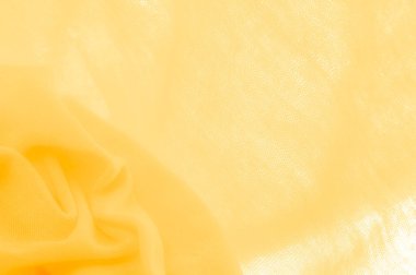 Sarı kumaş. Lüks kumaşın soyut arka planı ya da dalgaların sıvı ipek dokusu ya da dalgalı kıvrımlar. arka plan ya da zarif duvar kağıdı tasarımı. Pamuk dokusu, doğal kumaş ve boya, parlak sarı renk.