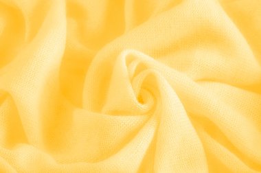 Sarı kumaş. Lüks kumaşın soyut arka planı ya da dalgaların sıvı ipek dokusu ya da dalgalı kıvrımlar. arka plan ya da zarif duvar kağıdı tasarımı. Pamuk dokusu, doğal kumaş ve boya, parlak sarı renk.