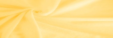 Sarı kumaş. Lüks kumaşın soyut arka planı ya da dalgaların sıvı ipek dokusu ya da dalgalı kıvrımlar. arka plan ya da zarif duvar kağıdı tasarımı. Pamuk dokusu, doğal kumaş ve boya, parlak sarı renk.