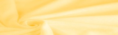 Sarı kumaş. Lüks kumaşın soyut arka planı ya da dalgaların sıvı ipek dokusu ya da dalgalı kıvrımlar. arka plan ya da zarif duvar kağıdı tasarımı. Pamuk dokusu, doğal kumaş ve boya, parlak sarı renk.