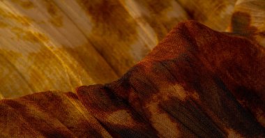 İnce organzadan yapılmış, panter derisini taklit eden ipek kumaş, kahverengi. Doku. Geçmişi. Şablon.