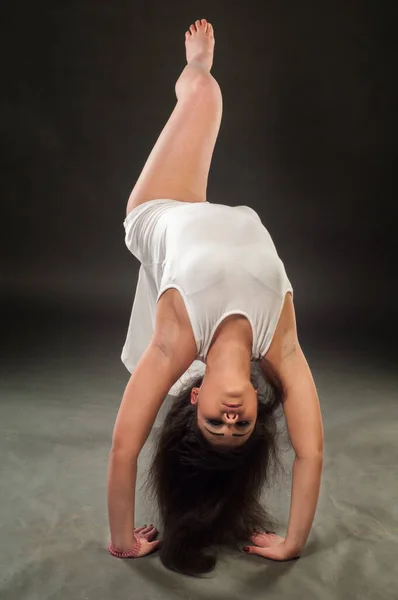 モデルのスタジオ写真 ブロンド女性彼女の腕を上げるとブレークダンスの基本的なステップを行う — ストック写真