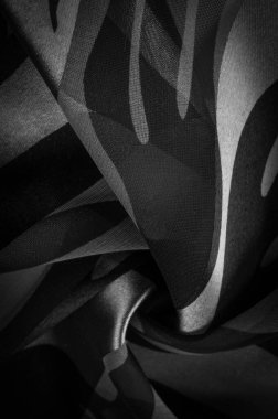 Doku. Şablon. şablon. Siyah ve beyazın soyut tonlarında ipek kumaş. İpek dokusu, soyutlama, tasarım ve duvar kağıdı için lüks saten.,