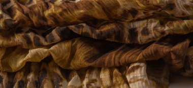 İnce organzadan yapılmış, panter derisini taklit eden ipek kumaş, kahverengi. Doku. Geçmişi. Şablon.