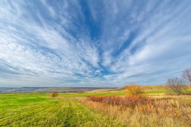 Sonbahar manzara fotoğrafçılığı, Dünya 'nın Avrupa kısmı. Günbatımında akşam gökyüzünün güzel bir gradyanı olan kırsal alan. Yeşil alan ve ufukta köy