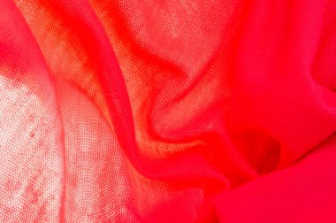 Kırmızı bez. Lüks kumaşın soyut arka planı ya da dalgaların sıvı ipek dokusu ya da dalgalı kıvrımlar. arka plan ya da zarif duvar kağıdı tasarımı. Pamuk dokusu, doğal kumaş ve boya, parlak kırmızı renk..