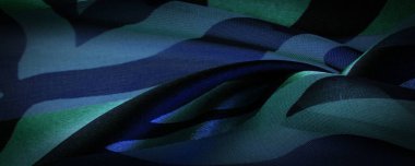 Doku. Şablon. şablon. Yeşil, siyah ve mavinin soyut tonlarında ipek kumaş. İpek dokusu, soyutlama, tasarım ve duvar kağıdı için lüks saten.