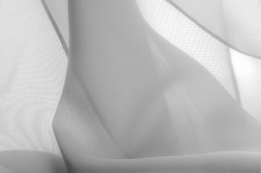 Doku. Desen. Beyaz ipek polyester. Hayalet beyaz ipek kumaştan. Şeffaf arkaplan ve elbise dikmek için açık kumaştan yapılmış. Tekstil panoraması