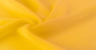 Doku. şablon. Sarı ipek polyester. Sarı ipek kumaşın arka planı. Şeffaf arkaplan ve elbise dikmek için açık kumaştan yapılmış. Tekstil panoraması.