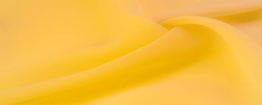 Doku. şablon. Sarı ipek polyester. Sarı ipek kumaşın arka planı. Şeffaf arkaplan ve elbise dikmek için açık kumaştan yapılmış. Tekstil panoraması.