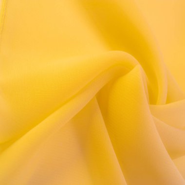Doku. şablon. Sarı ipek polyester. Sarı ipek kumaşın arka planı. Şeffaf arkaplan ve elbise dikmek için açık kumaştan yapılmış. Tekstil panoraması.