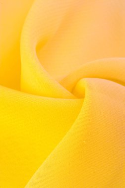 Doku. şablon. Sarı ipek polyester. Sarı ipek kumaşın arka planı. Şeffaf arkaplan ve elbise dikmek için açık kumaştan yapılmış. Tekstil panoraması.