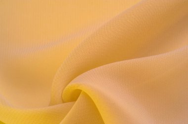 Doku. şablon. Sarı ipek polyester. Sarı ipek kumaşın arka planı. Şeffaf arkaplan ve elbise dikmek için açık kumaştan yapılmış. Tekstil panoraması.