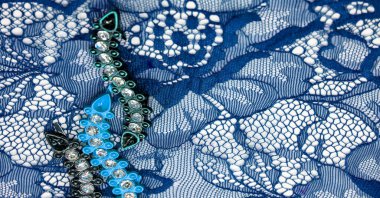 Beyaz arka planda mavi dantel kumaş. Süslü Afrika tüllü dantel kumaş polyester. Tasarımın için uzun boylu çiçekler. Doku. Geçmişi. Desen