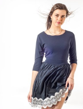 Dantelli siyah elbiseli bir manken. Siyahlı genç bir kadının stüdyo fotoğrafı. Siyah kokteyl elbisesi içinde zarif bir kadın. Dantel elbiseyle poz veren genç ve güzel bayan.,