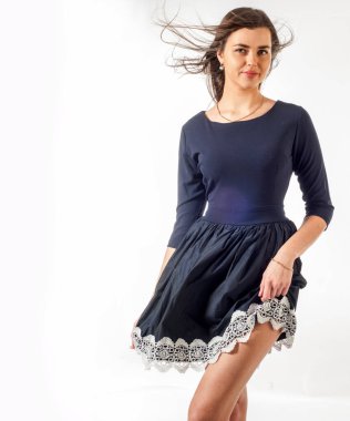 Dantelli siyah elbiseli bir manken. Siyahlı genç bir kadının stüdyo fotoğrafı. Siyah kokteyl elbisesi içinde zarif bir kadın. Dantel elbiseyle poz veren genç ve güzel bayan.,