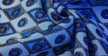 Yumuşak mavi ipekten kumaş eşkenar dörtgen, kare ve madalyalar. Bir hikaye anlat ve geleneksel tasarım ile etkileyici ve değerli bir açıklama yap. Desen arkaplan deseni