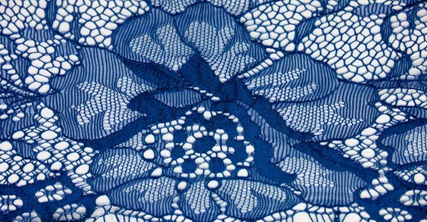 Blue lace fabric on a white background. Fancy African tulle lace fabric polyester with full length flowers for your design. The texture. Background. Pattern