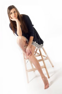 Dantelli siyah elbiseli bir manken. Siyahlı genç bir kadının stüdyo fotoğrafı. Siyah kokteyl elbisesi içinde zarif bir kadın. Dantel elbiseyle poz veren genç ve güzel bayan.,