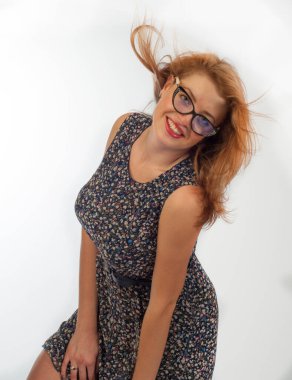 Model fotoğraf stüdyosu. Çiçekli elbiseli, gözlüklü seksi kadın. Uzun beyaz, çekici, neşeli, mutlu, seksi model, kahverengi saçlı.