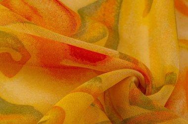 Doku, Desen. Soyut kırmızı baskı ile pürüzsüz sarı kumaş dokusu. Lüks soyut bir arka plan. Lüks Noel geçmişi. Kumaş, narin.