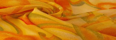 Doku, Desen. Soyut kırmızı baskı ile pürüzsüz sarı kumaş dokusu. Lüks soyut bir arka plan. Lüks Noel geçmişi. Kumaş, narin.