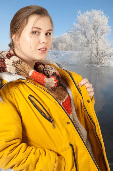 girl in a winter jacket. Smiling Winter Girl. Sweet young girl in warm winter jacket with fur hood, looking up with a cute smile on her face,