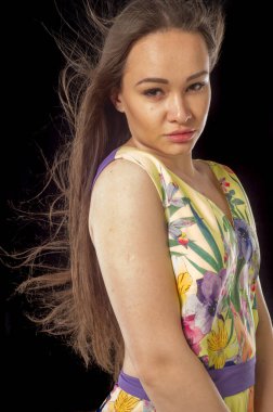 Seksi, açık elbisenin içinde. Rüzgâr saçlarını geliştirir. Portre. Muhteşem dolgun dudakları olan güzel kahverengi saçlı kız.