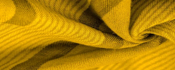 Texture. Background. Silk fabric of yellow color, of the color between green and orange in the spectrum, a primary subtractive color complementary to blue; colored like ripe lemons or egg yolks.