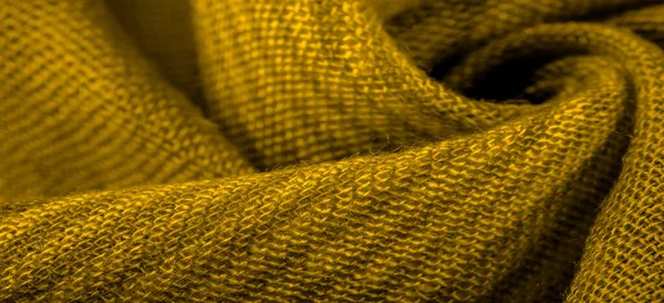 Texture. Background. Silk fabric of yellow color, of the color between green and orange in the spectrum, a primary subtractive color complementary to blue; colored like ripe lemons or egg yolks.
