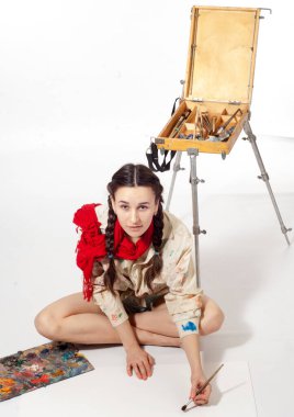 Resim için fırçası olan bir kız, şövalesi olan bir sanatçı.