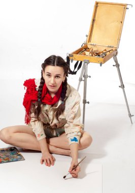 Resim için fırçası olan bir kız, şövalesi olan bir sanatçı.