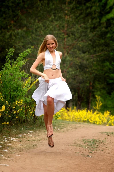 Mankenin yaz fotoğrafı. Çam ormanında beyaz elbiseli bir kız.