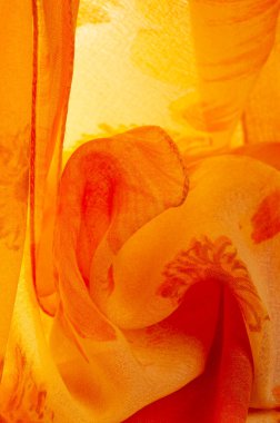 Boyanmış çayır çiçekleri ve çiçek arkaplanlı turuncu ipek kumaş. Renkli bir kompozisyonda bir sürü soluk çiçek. Arkaplan dokusu