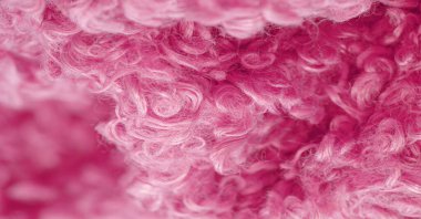 Karakul yapay koç derisi. Kırmızı renk. Genç bir astrakhan (kuzu) kumaşının altında inanılmaz kalitede yapay eko-kürk. Özel tasarım, palto kumaşı, doku, arka plan, desen.