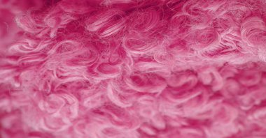 Karakul yapay koç derisi. Kırmızı renk. Genç bir astrakhan (kuzu) kumaşının altında inanılmaz kalitede yapay eko-kürk. Özel tasarım, palto kumaşı, doku, arka plan, desen.