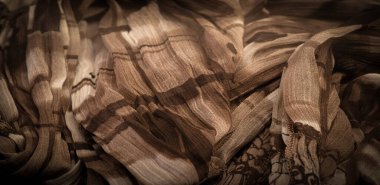 Kahverengi ipek kumaş, çiçek desenli. Dalgalı kıvrımlar. Kumaşın yüzeyinde ince bir dalga var. Arkaplan dokusu, dekoratif süs